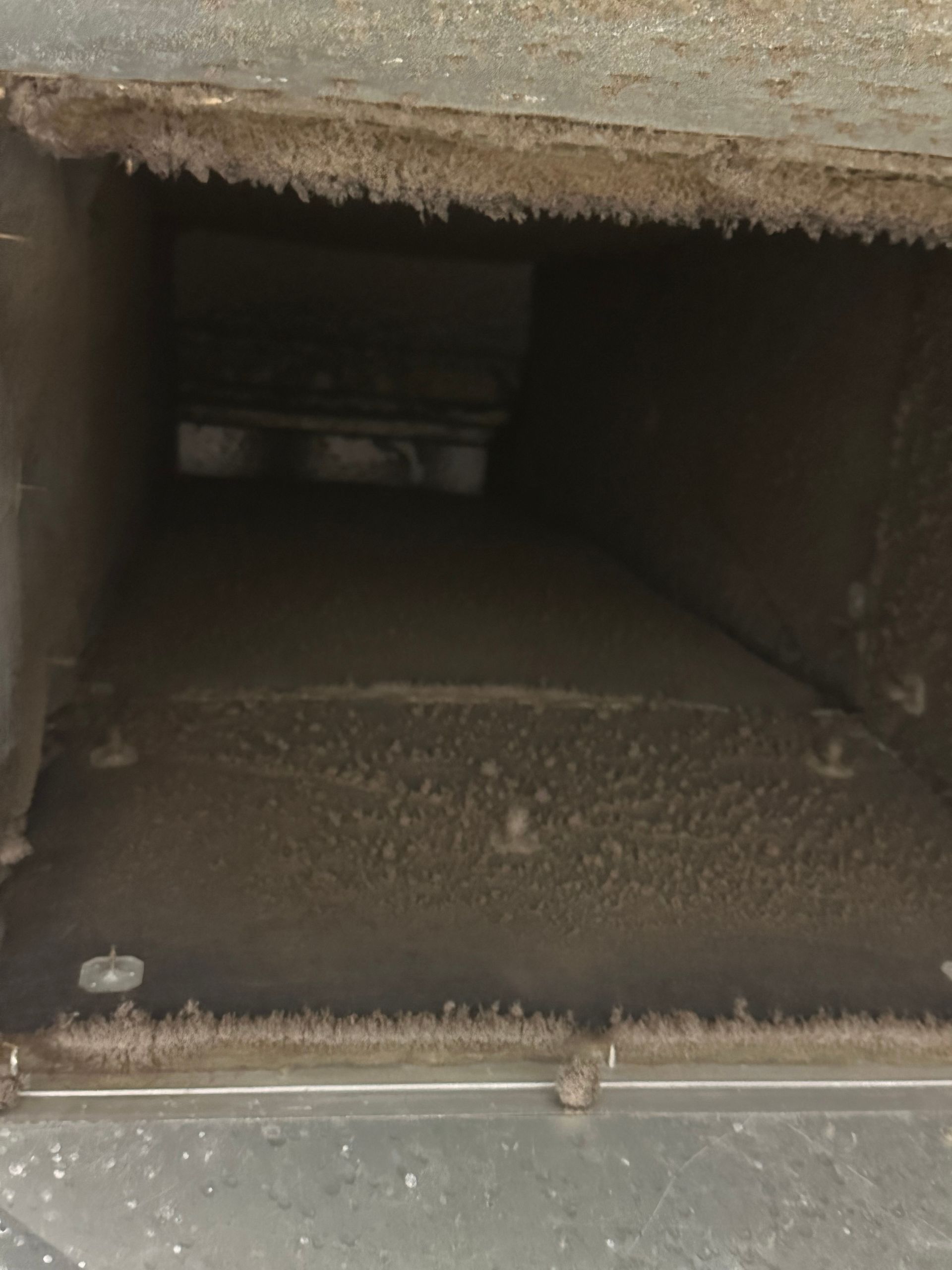 Dusty rectangular duct interior.