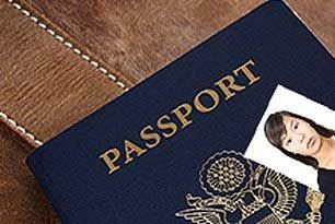 Dark blue passport with gold lettering and a photo next to it, resting on a brown leather surface.