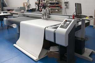 Large format cutting machine with a roll of white material.