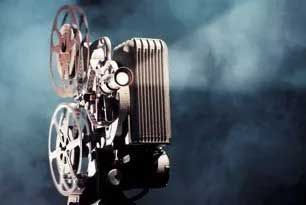 Vintage film projector against a misty, dark blue background.