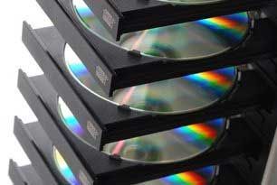 CDs in a multi-disc player, showing rainbow reflections.