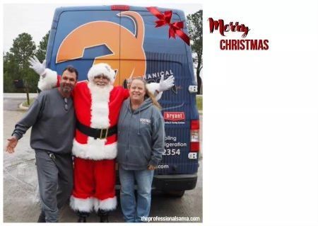 Three people posing with a work van and a 