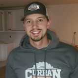 A man wearing a hat and a hoodie that says curlan