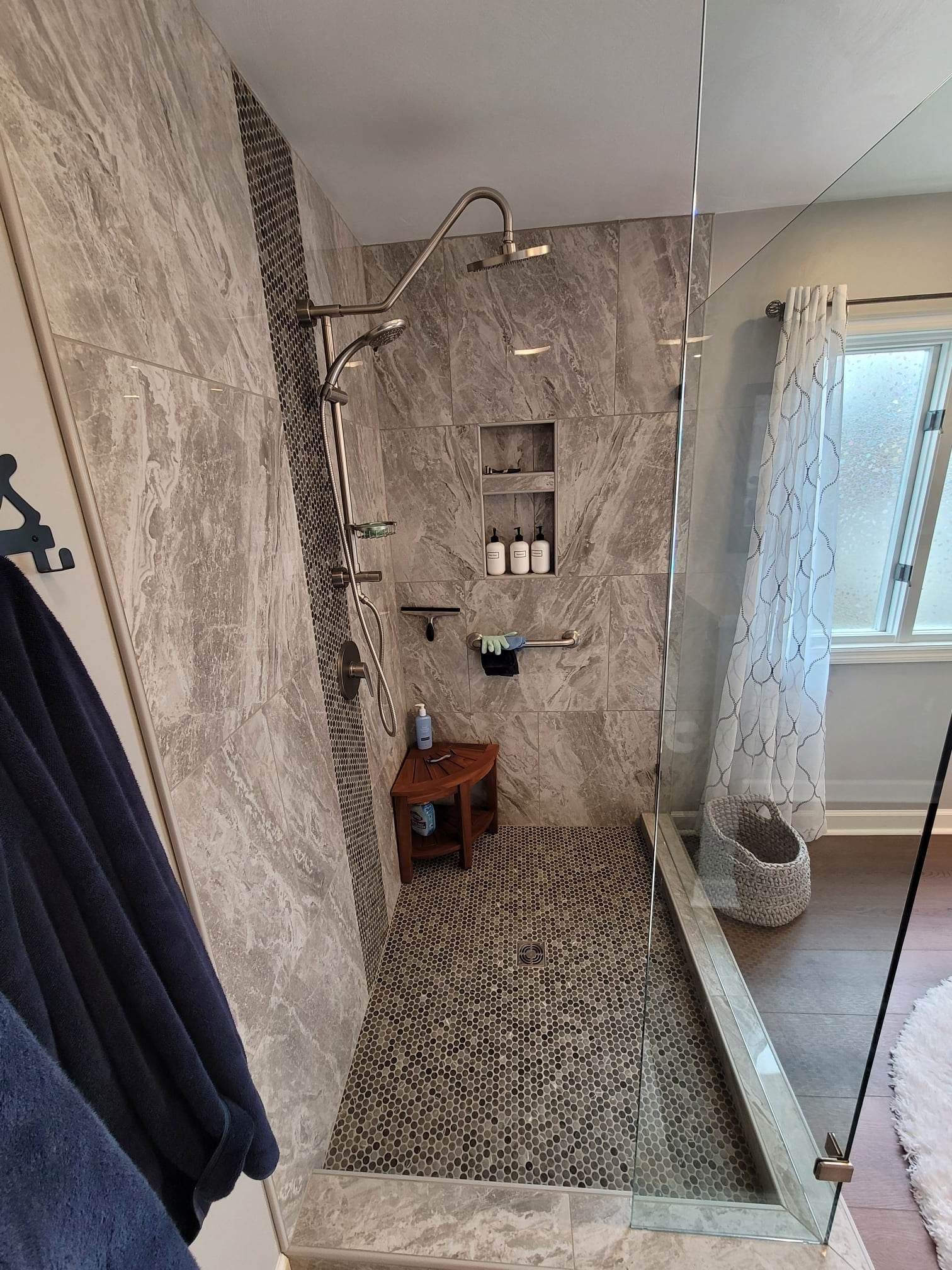 A bathroom with a walk in shower and a window.