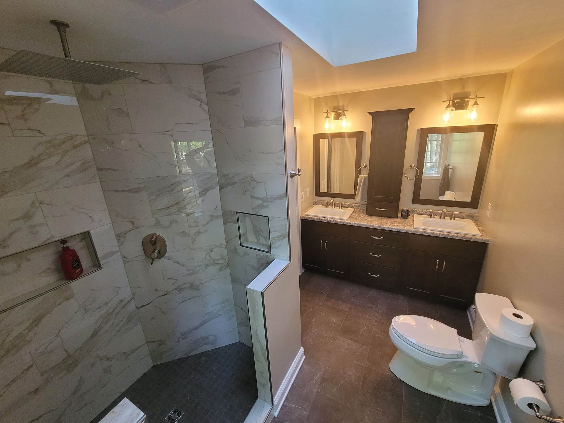 A bathroom with a toilet , sink and shower.