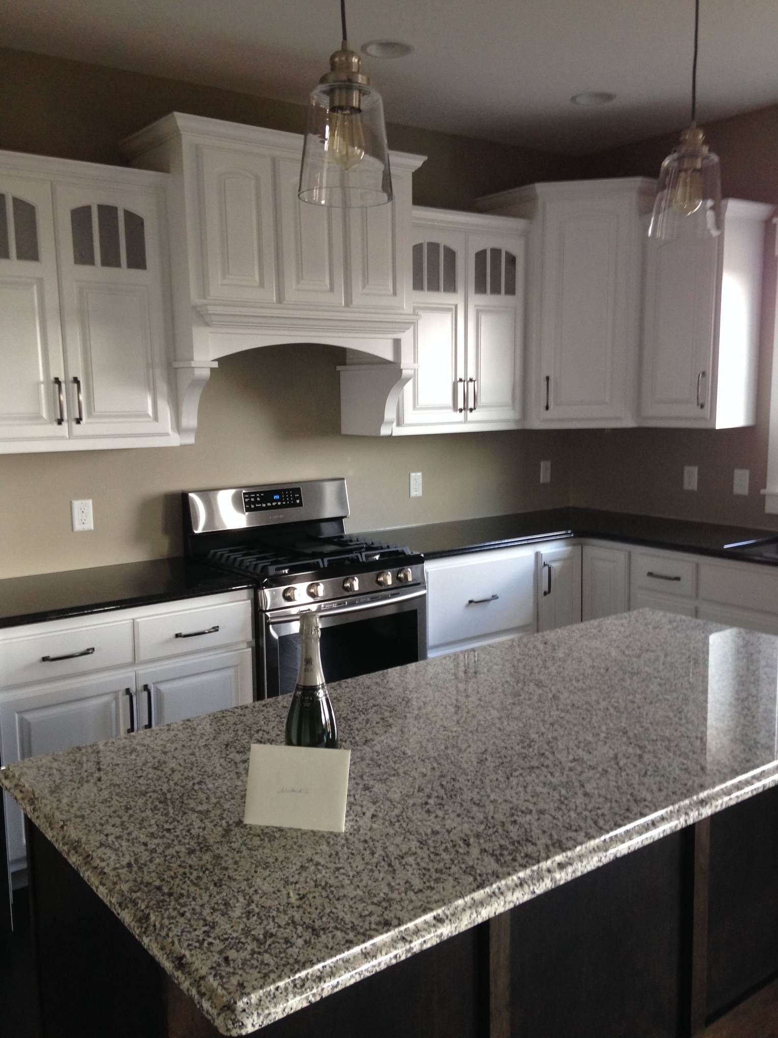 A kitchen with white cabinets and granite counter tops