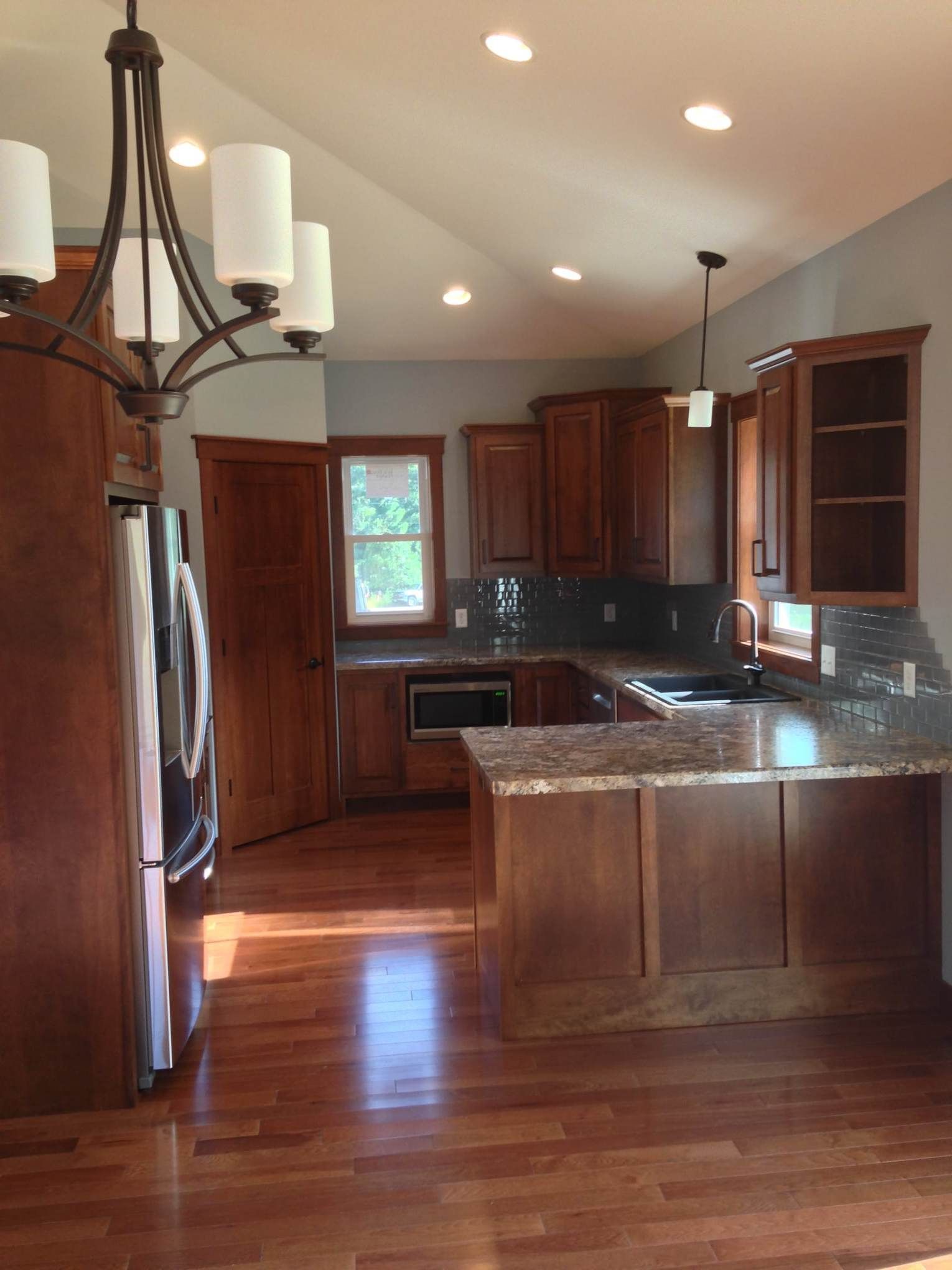 An empty kitchen with wooden cabinets and granite counter tops