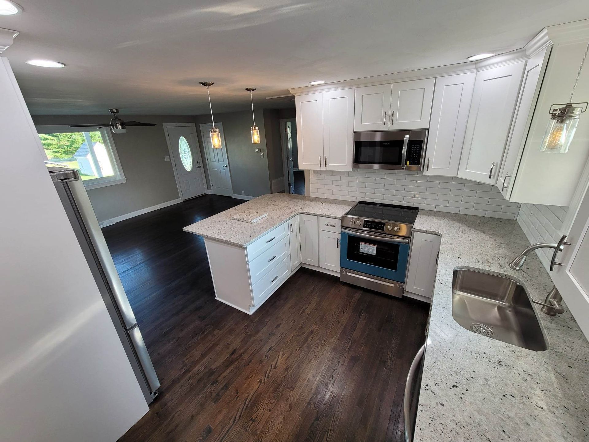 A kitchen with white cabinets , stainless steel appliances , a sink , and a stove.