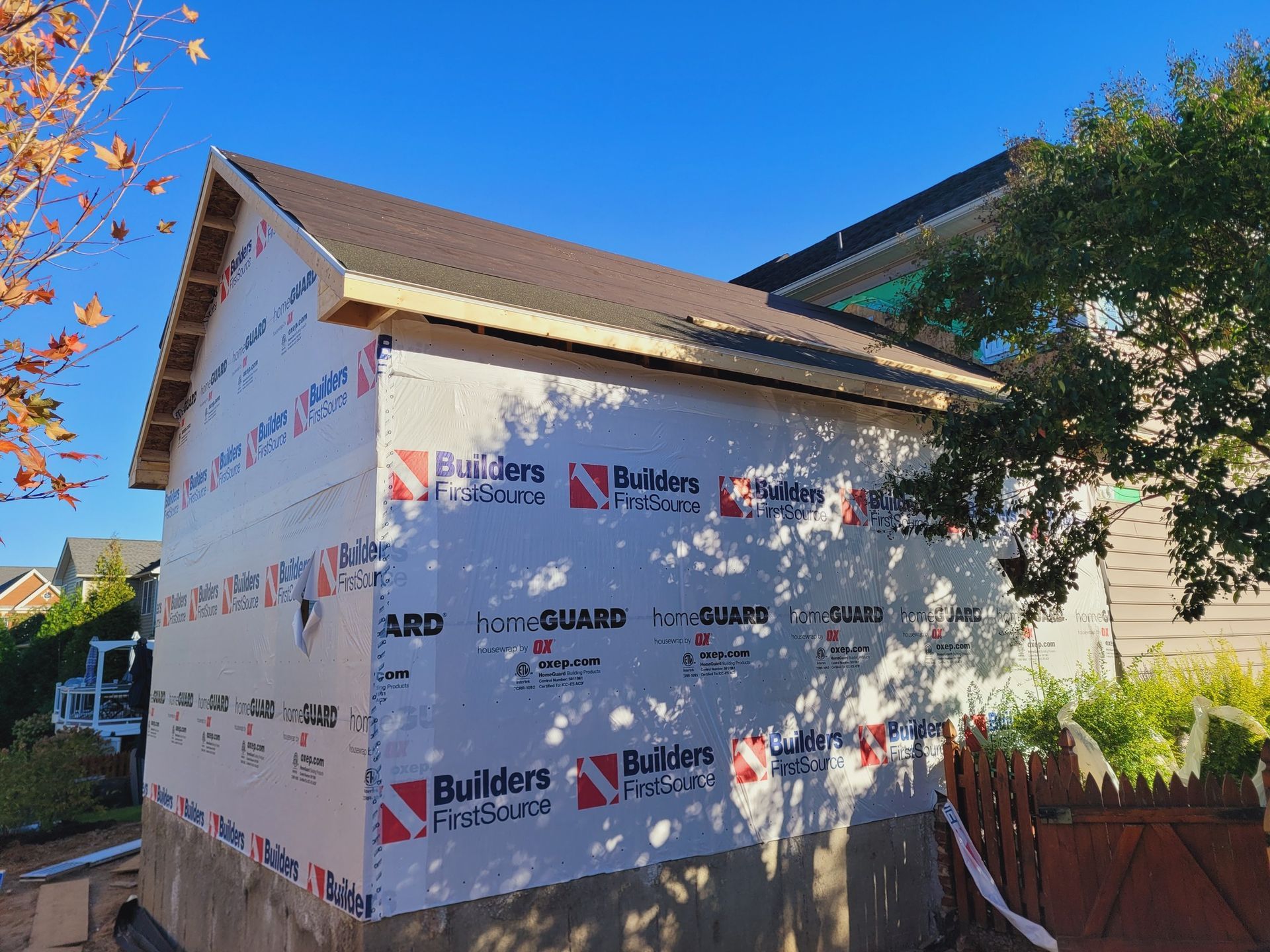 A house is being built with builders ' guard siding on the side.