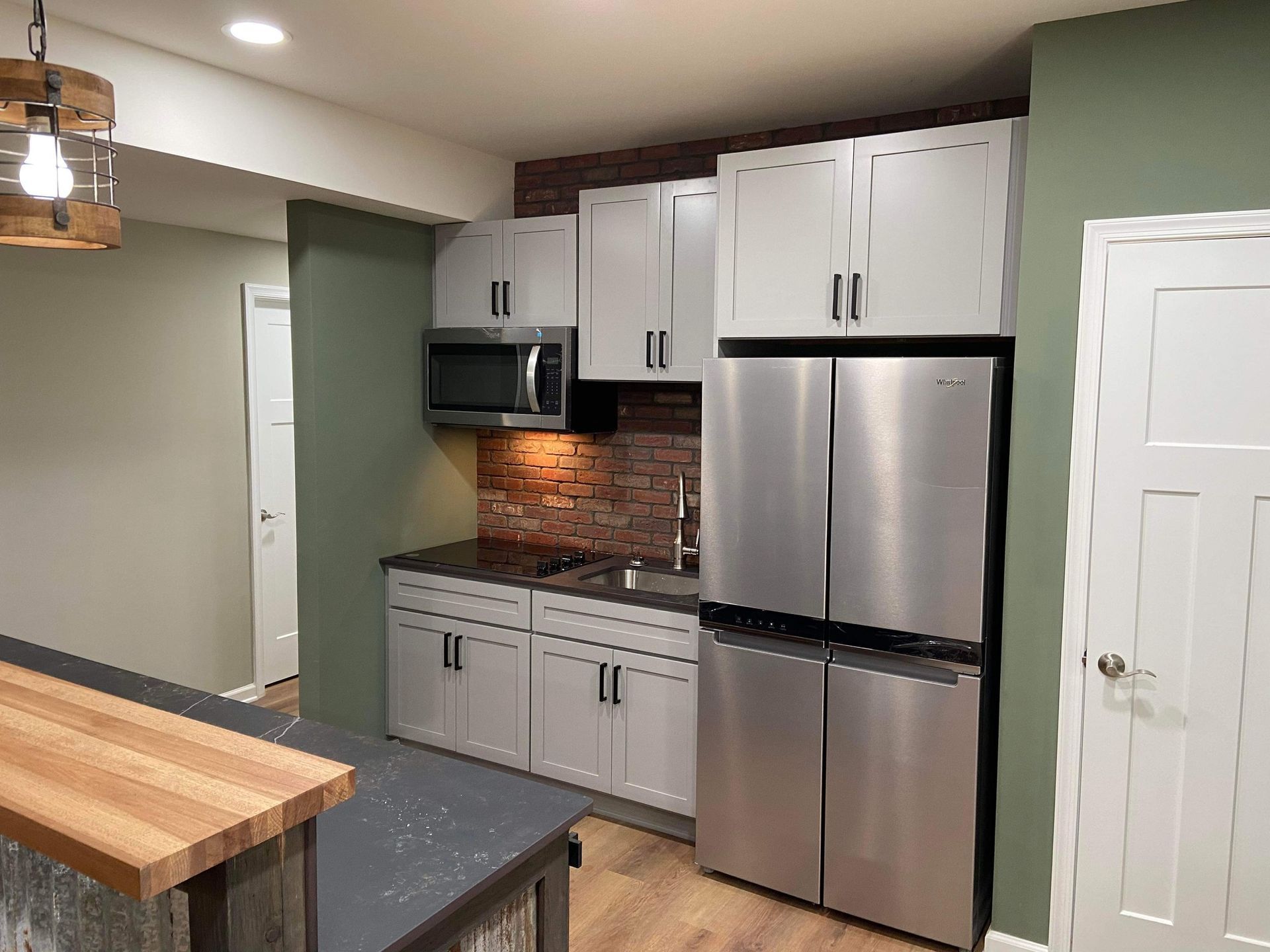 A kitchen with stainless steel appliances and white cabinets.