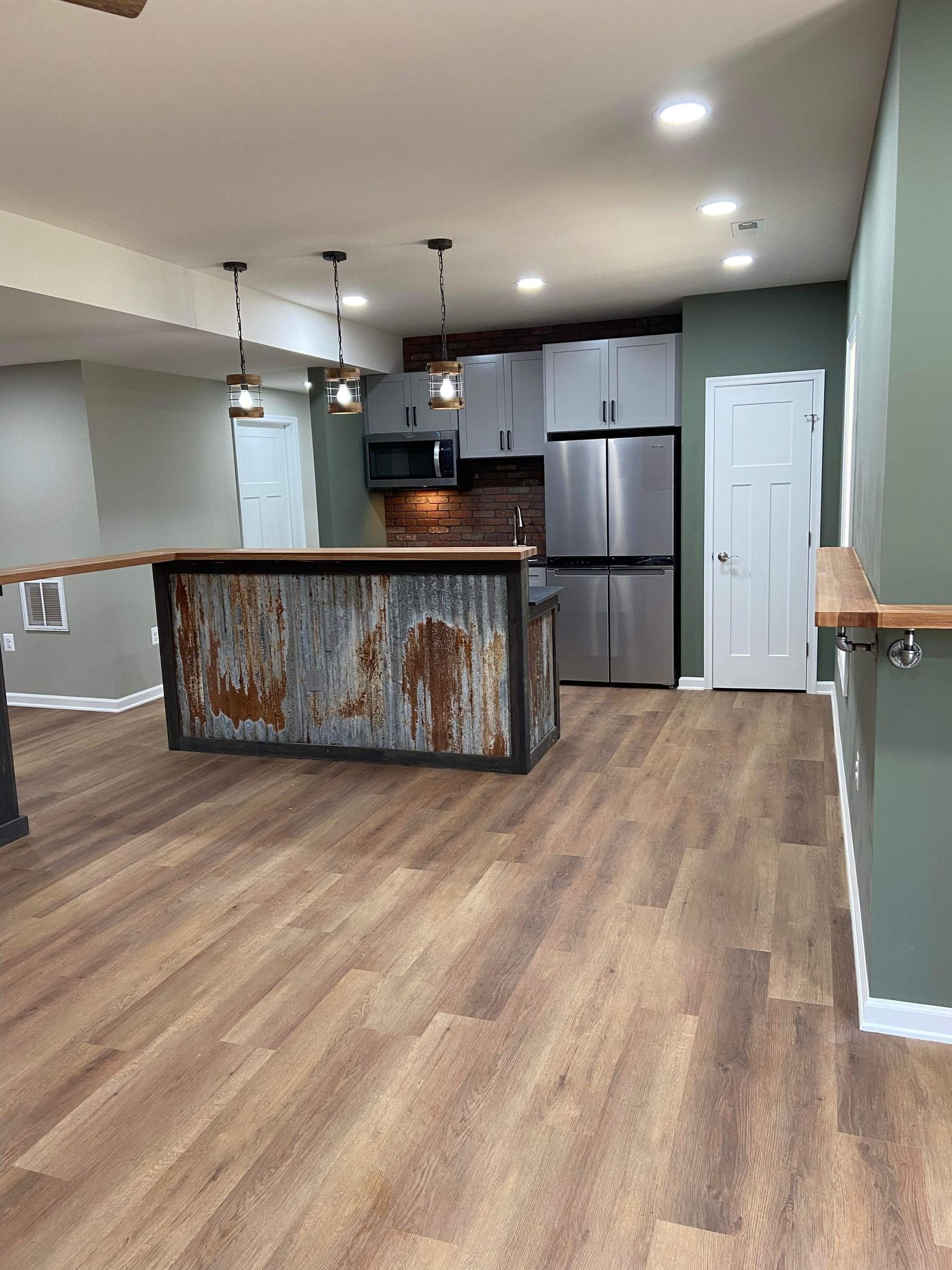 A kitchen with stainless steel appliances and a large island in the middle of the room.