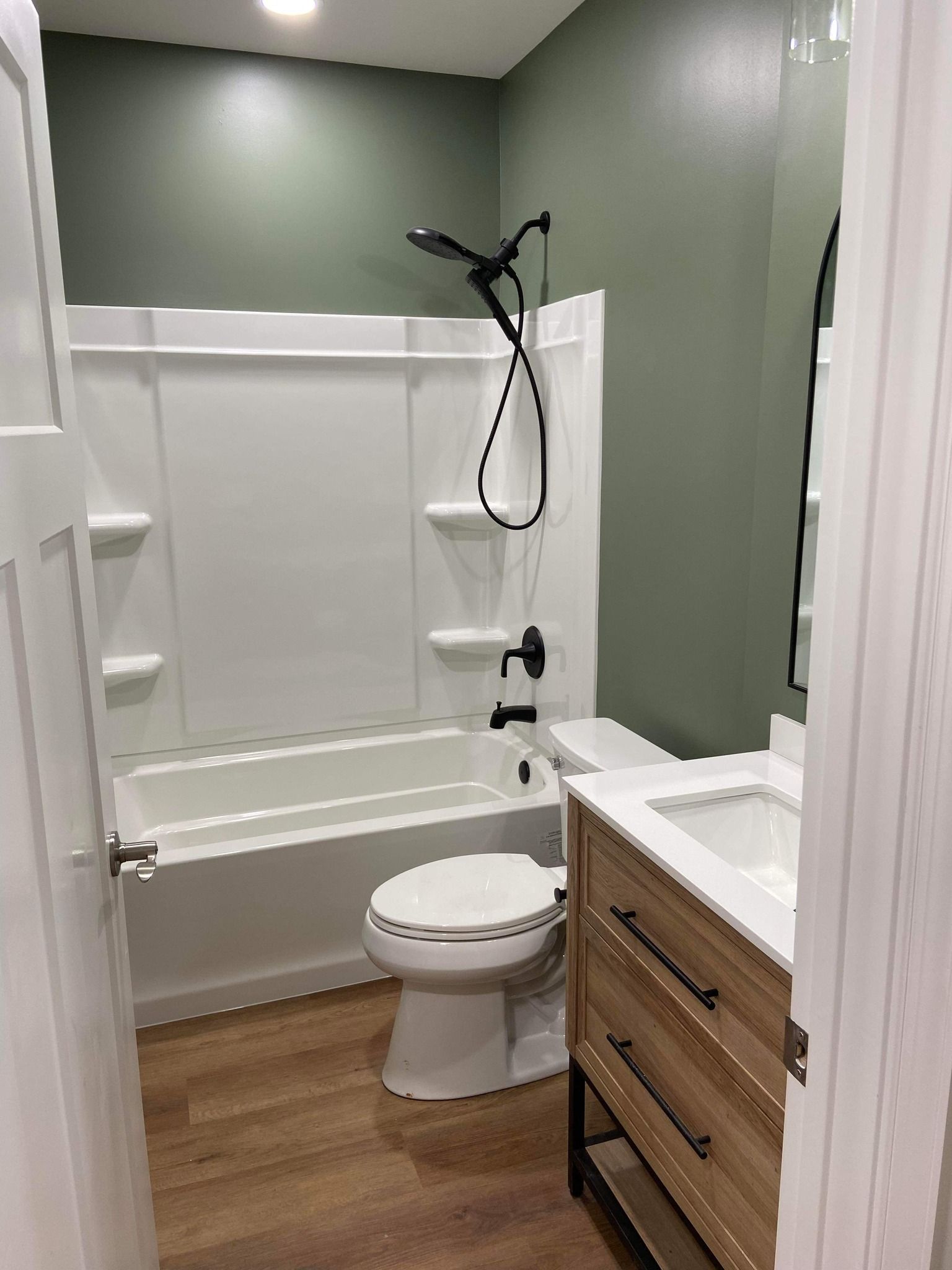 A bathroom with a toilet , sink , bathtub and shower.