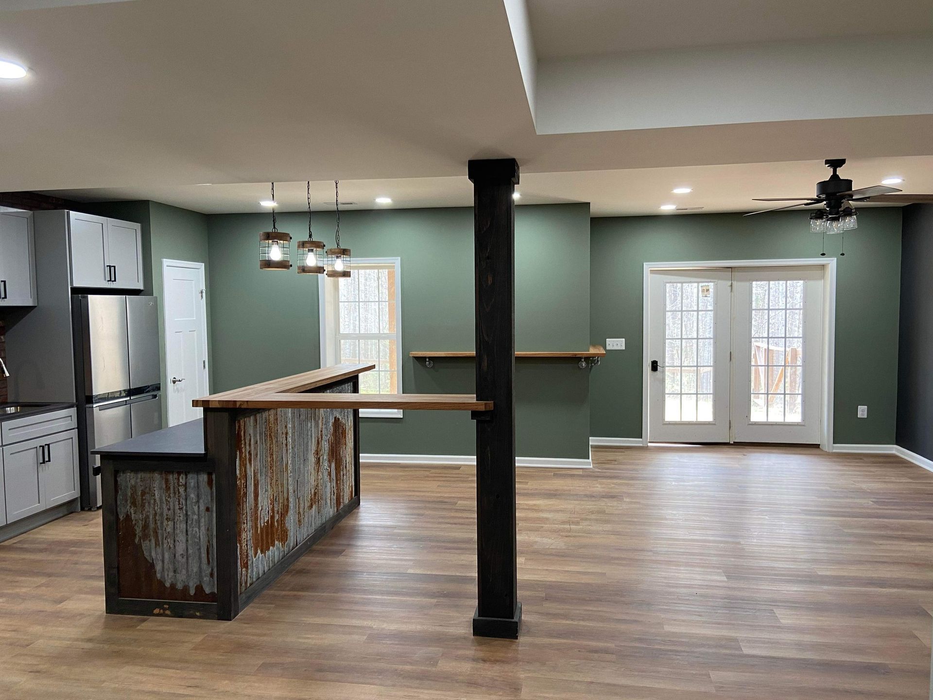 A kitchen with a bar and a ceiling fan