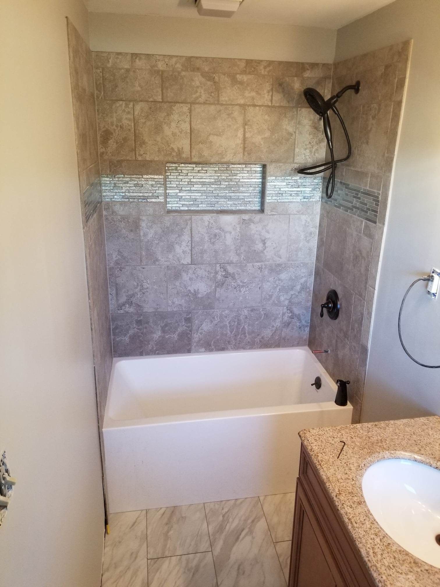 A bathroom with a bathtub , sink and shower.