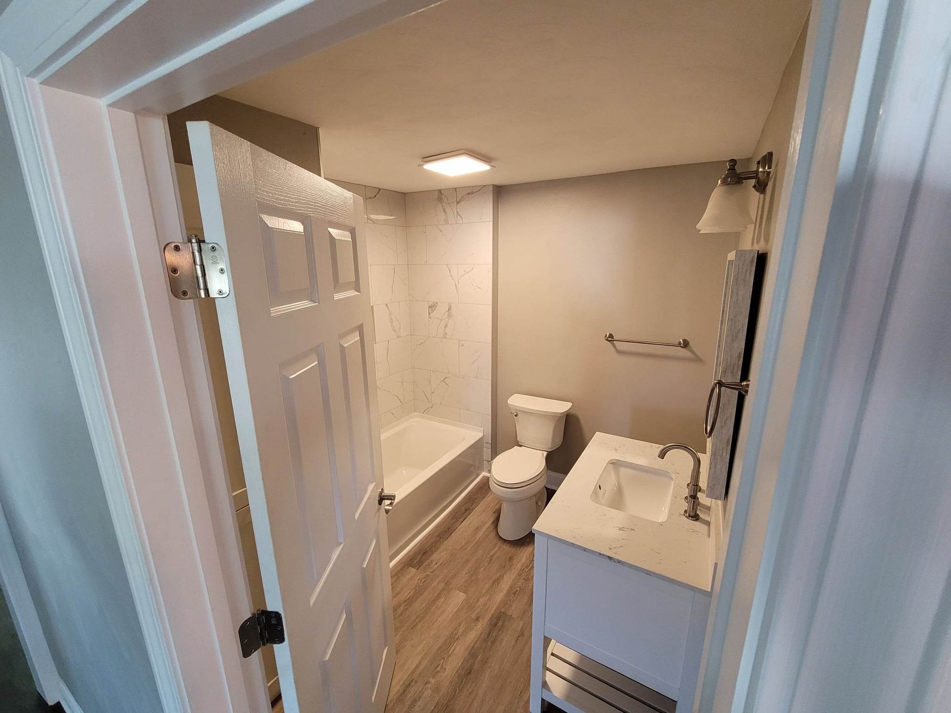 A bathroom with a toilet , sink and bathtub.