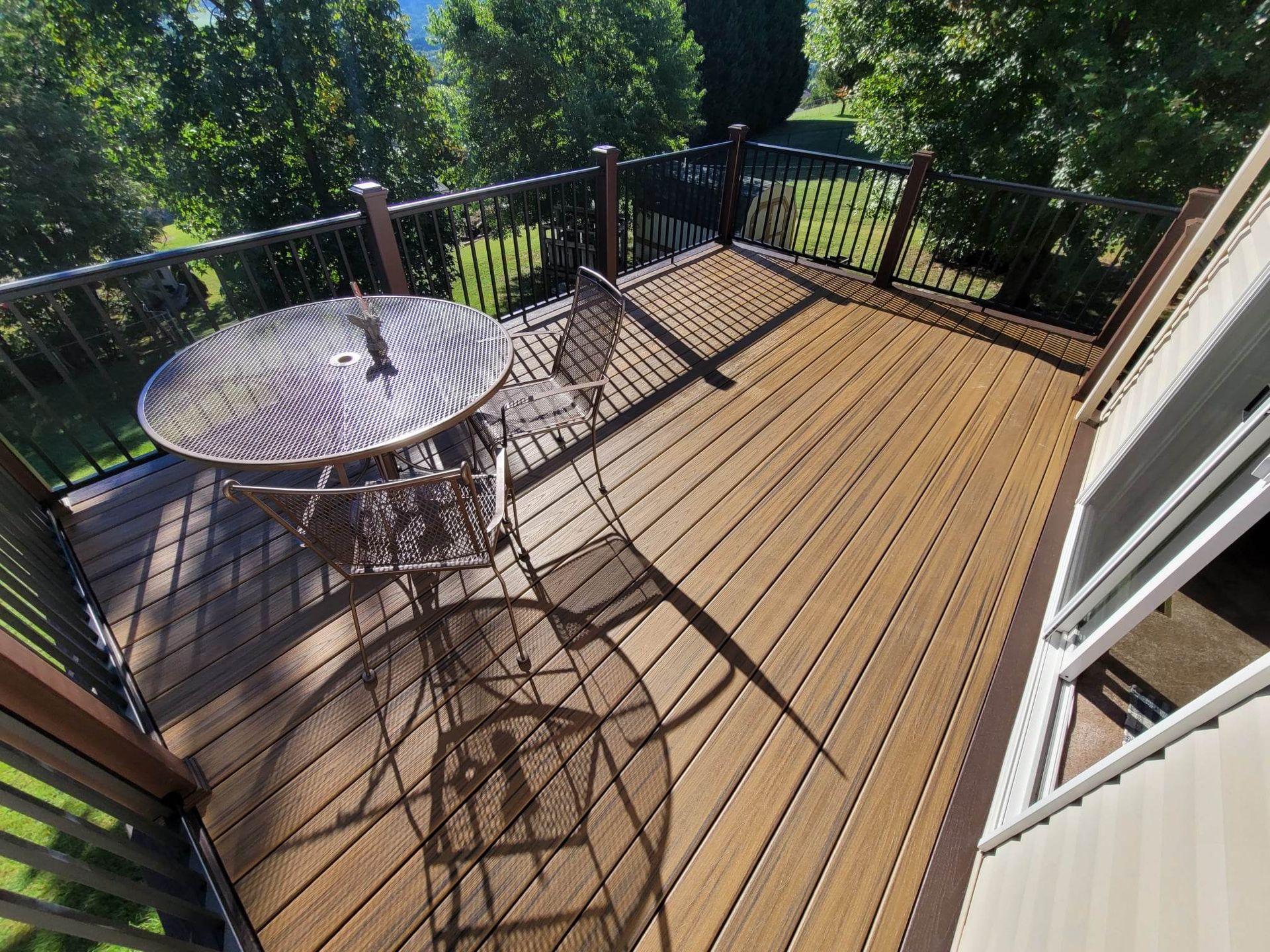 A wooden deck with a table and chairs on it.