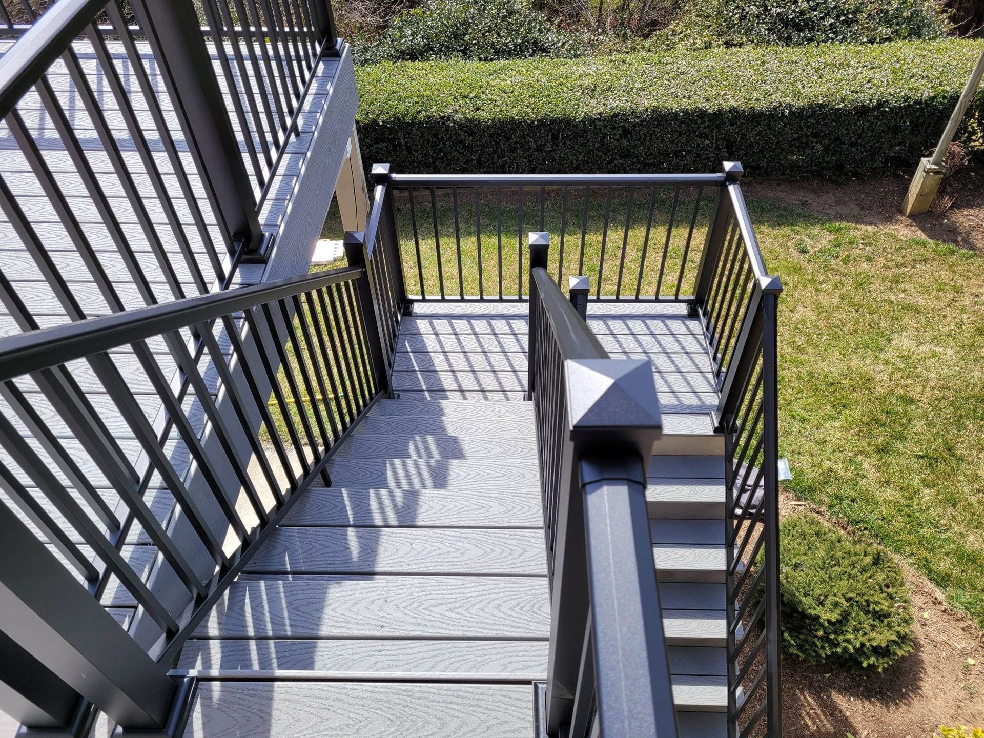 A set of stairs leading up to a deck with a metal railing.