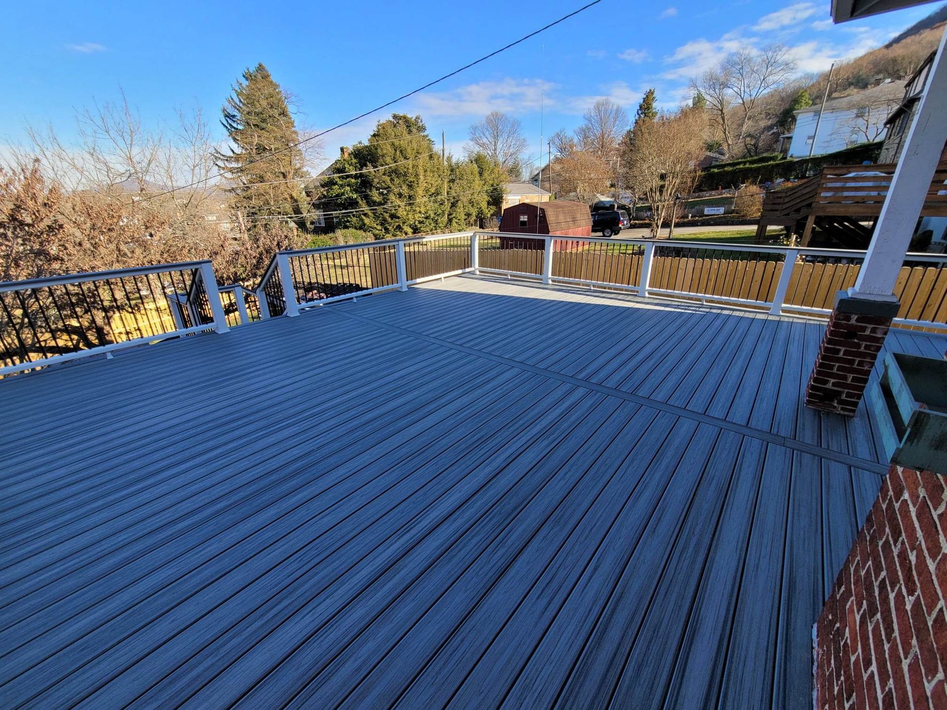 A large empty deck with a fence and trees in the background