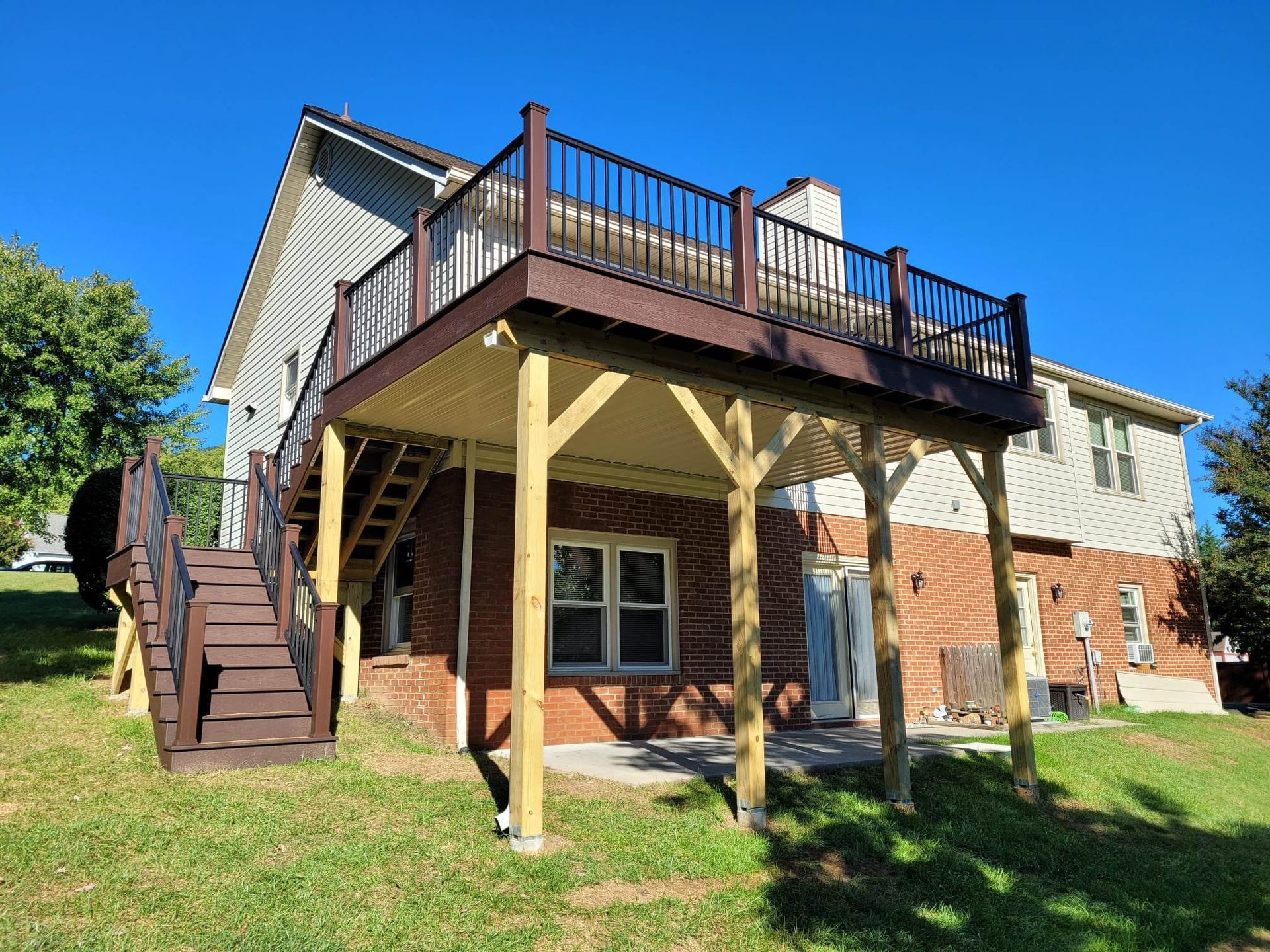 The back of a house with a large deck and stairs.