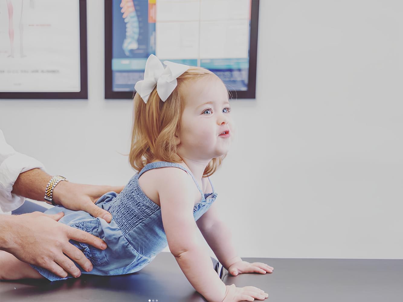 Little girl with red hair being examined by a doctor, looking up.