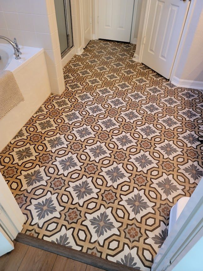 A bathroom with a patterned floor and a bathtub