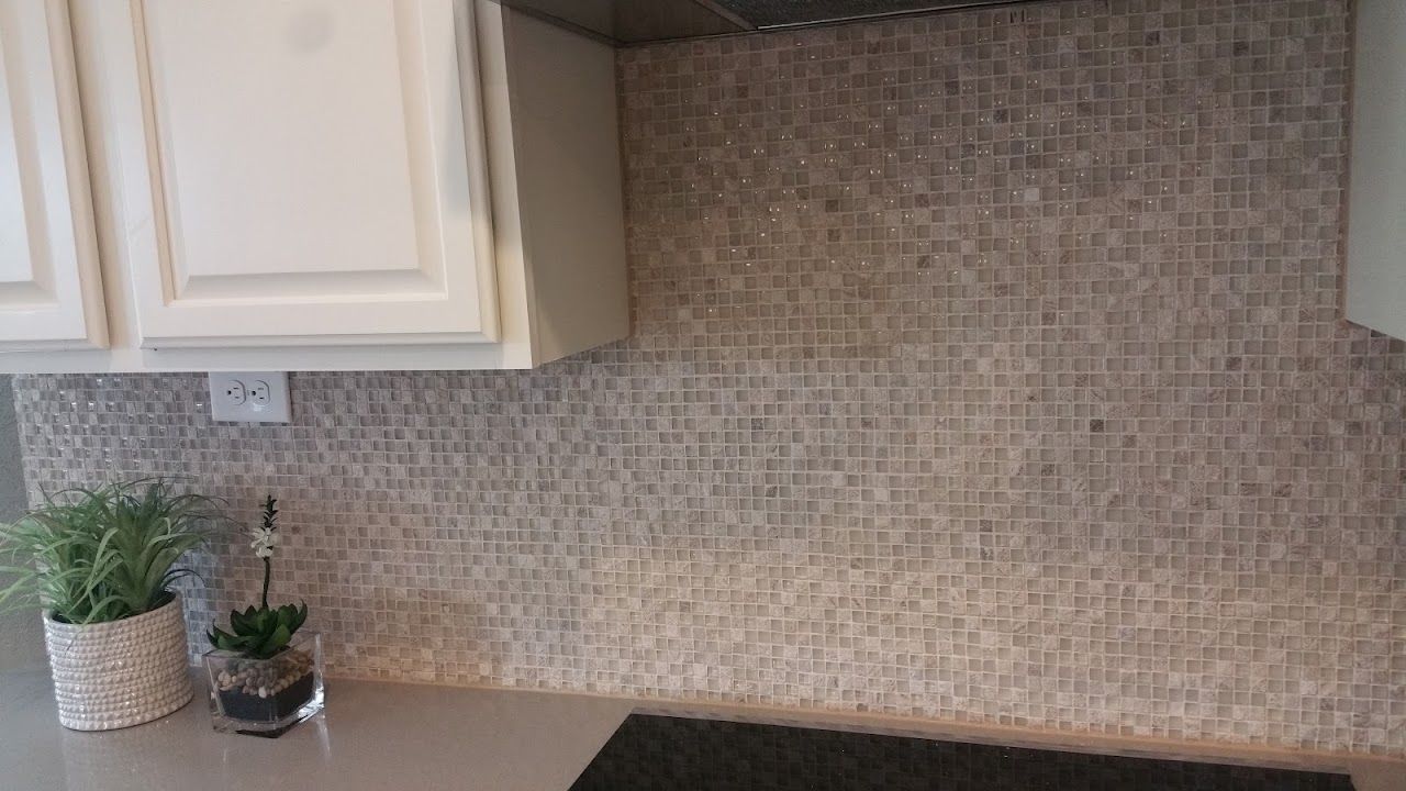 A kitchen counter with a potted plant and a stove top oven.