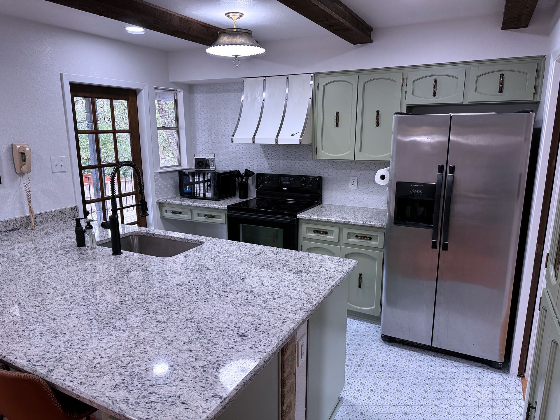 A kitchen with granite counter tops and stainless steel appliances.