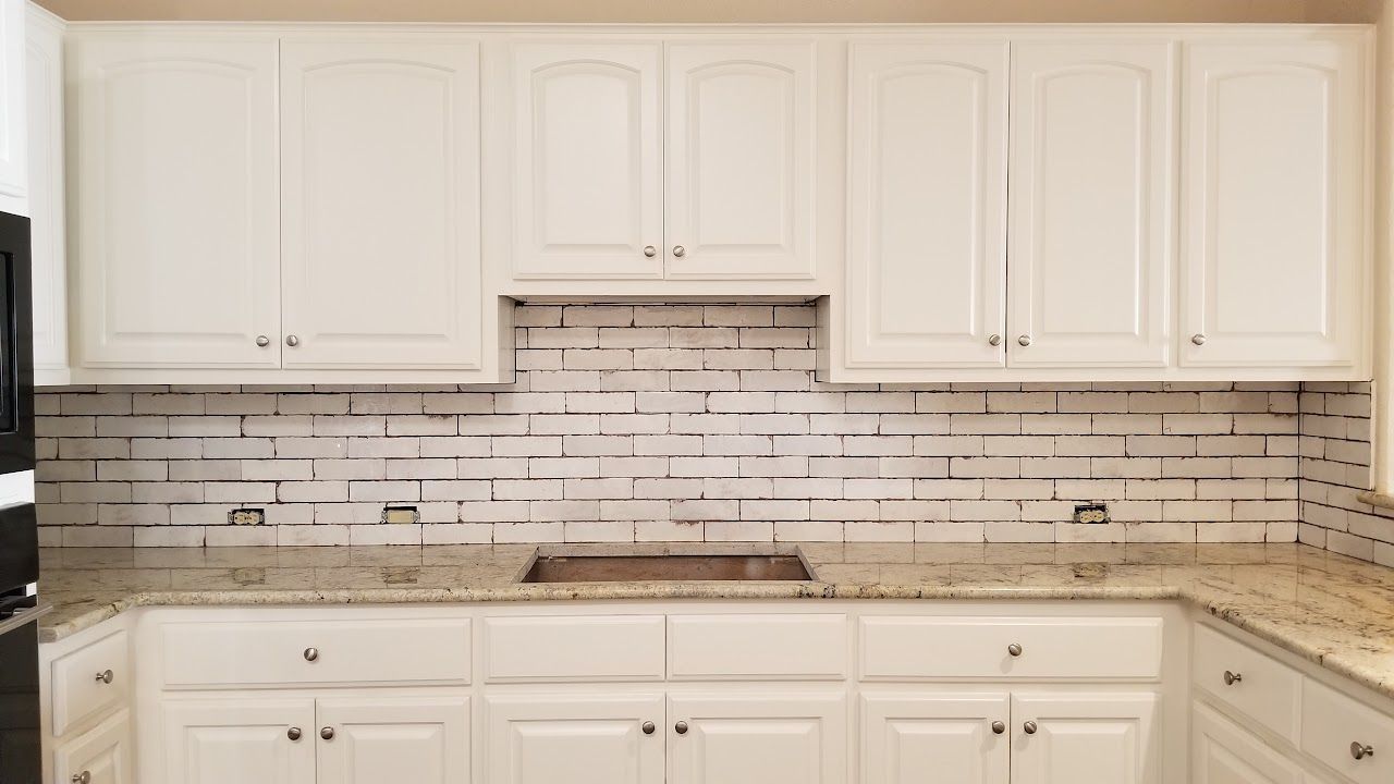 A kitchen with white cabinets and granite counter tops