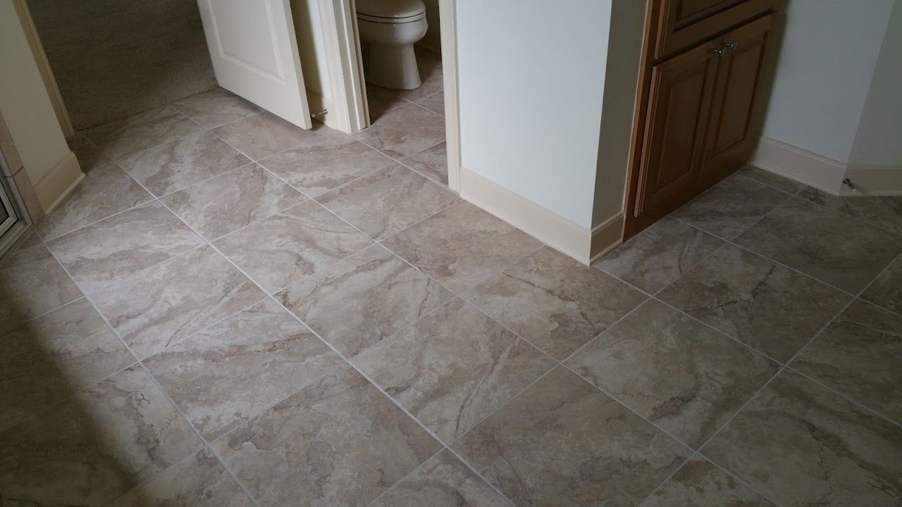 A bathroom with a tiled floor and a toilet