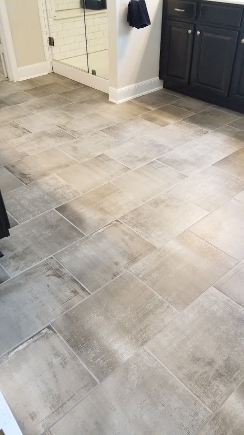 A bathroom with a tile floor and black cabinets
