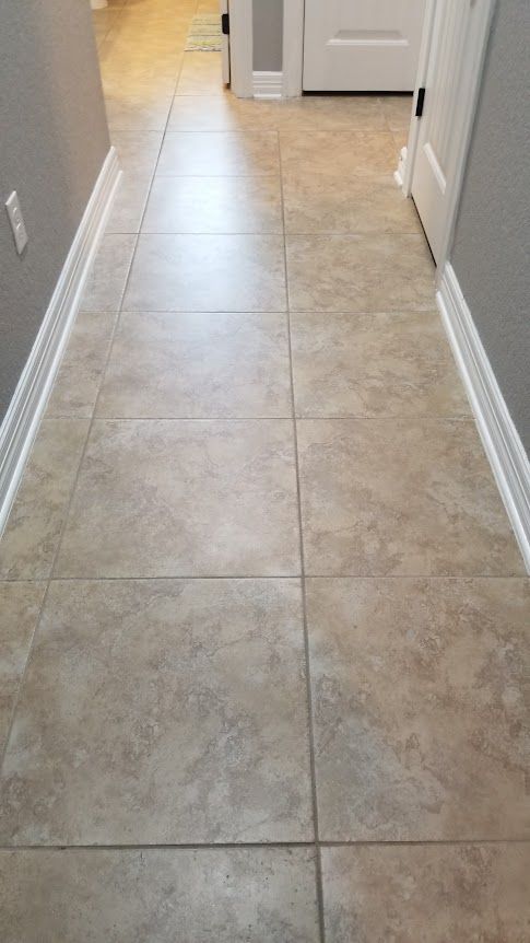 A hallway with tile floors and white trim
