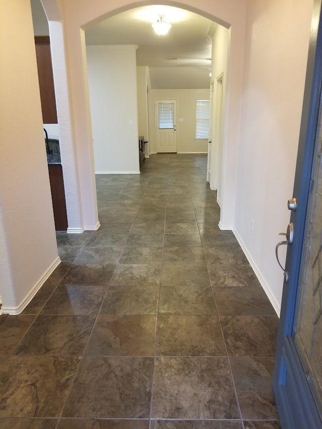 A hallway in a house with tile floors and a blue door