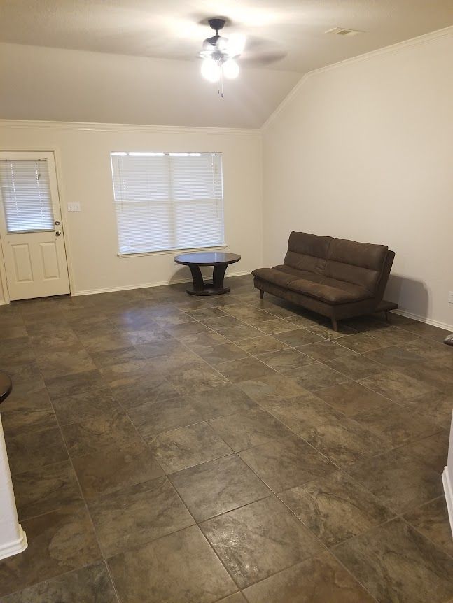 A living room with a couch, table, and window