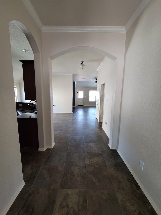A hallway leading to a kitchen and a living room in a house