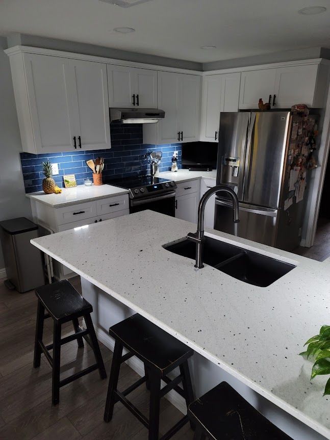 A kitchen with white cabinets and stainless steel appliances