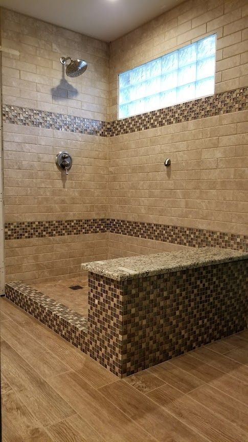 A bathroom with a walk-in shower and a window