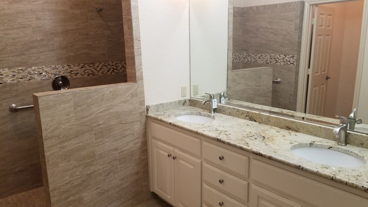 A bathroom with two sinks and a walk-in shower