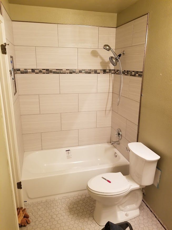 A bathroom with a toilet, bathtub, and shower