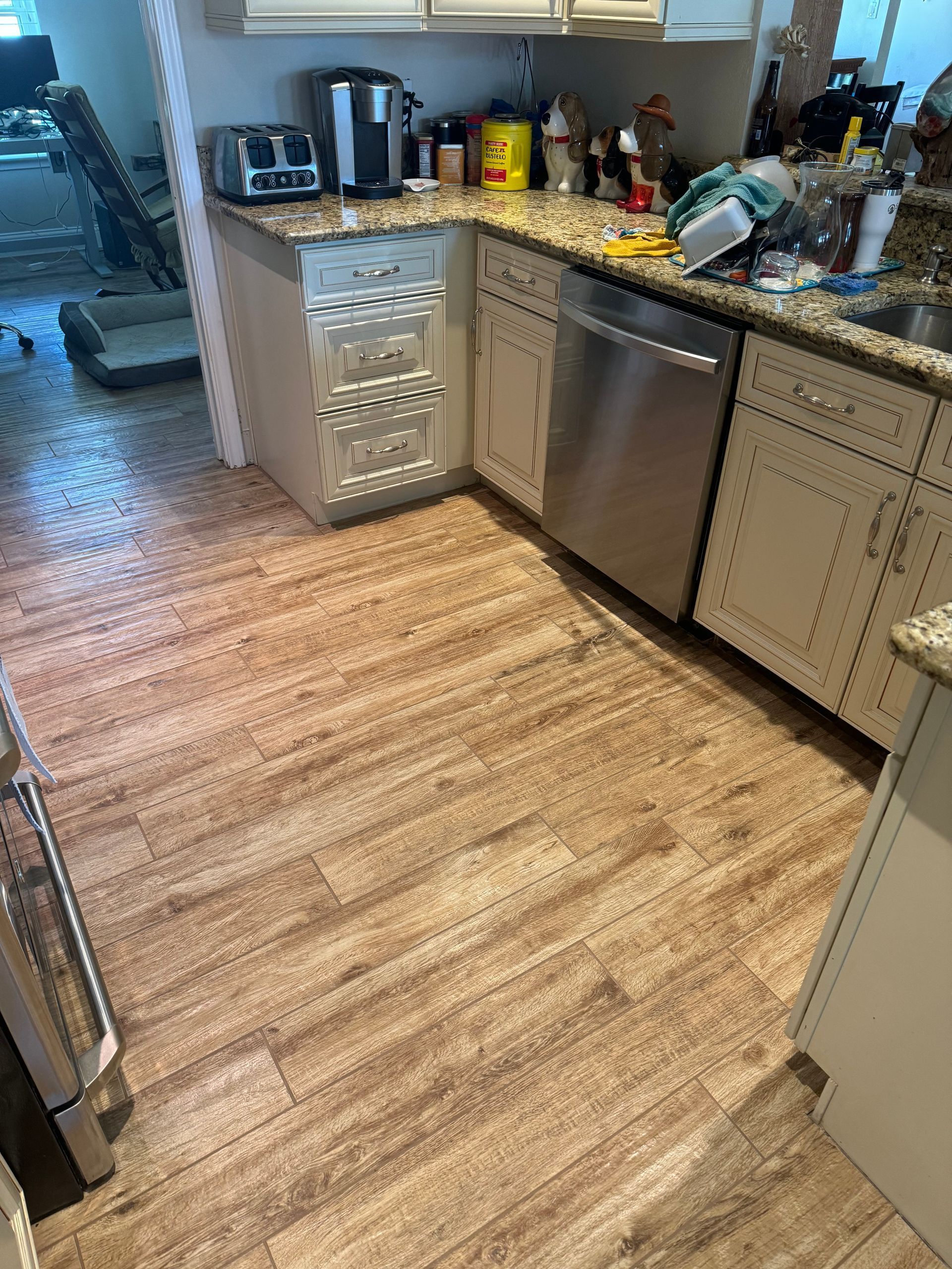 A kitchen with a wooden floor and stainless steel appliances.