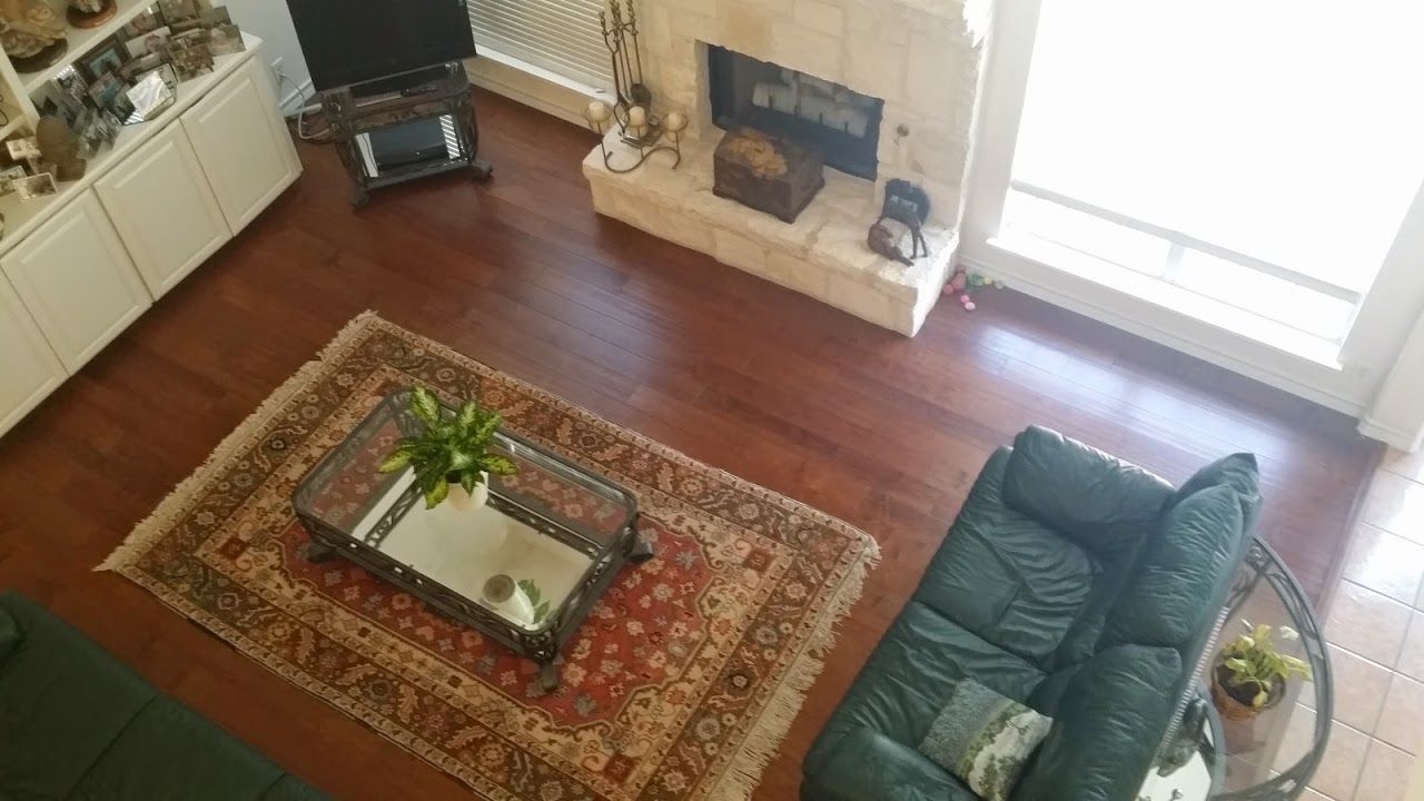 An aerial view of a living room with a couch, rug, coffee table, and fireplace