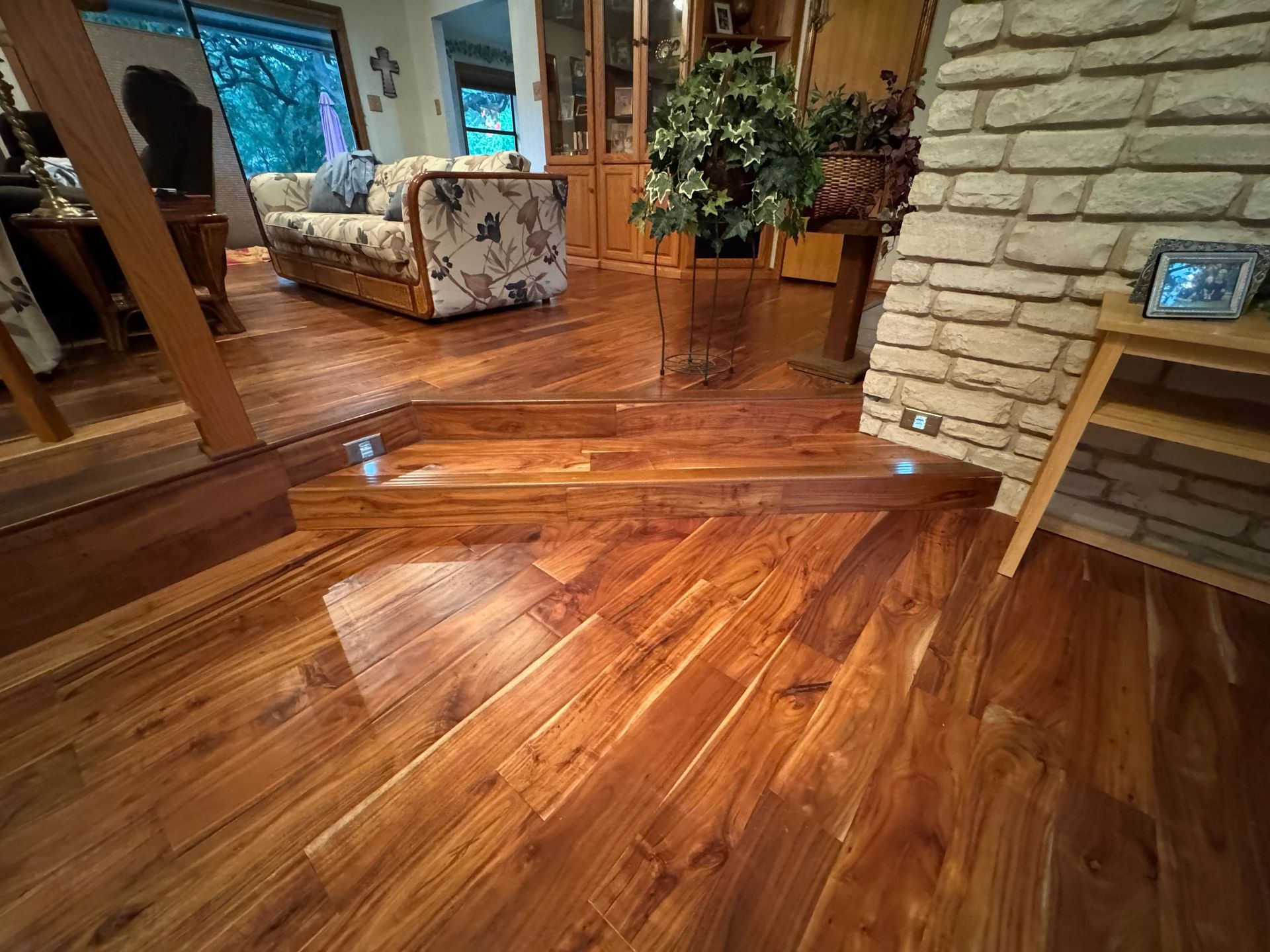 A living room with hardwood floors and a brick fireplace