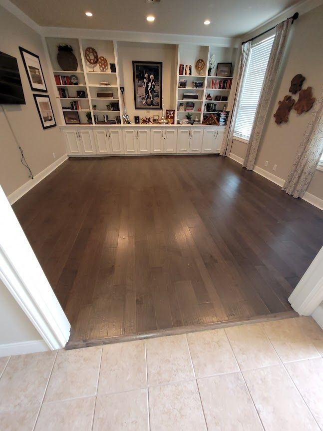 A living room with hardwood floors and built in shelves.