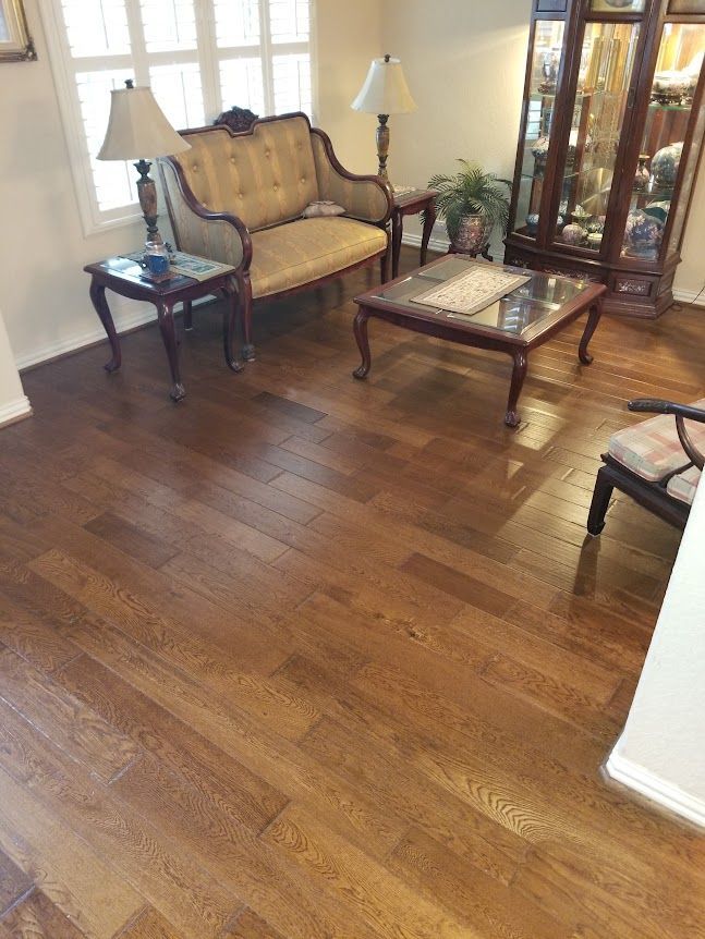 A living room with hardwood floors, a couch, a coffee table, and a chair.
