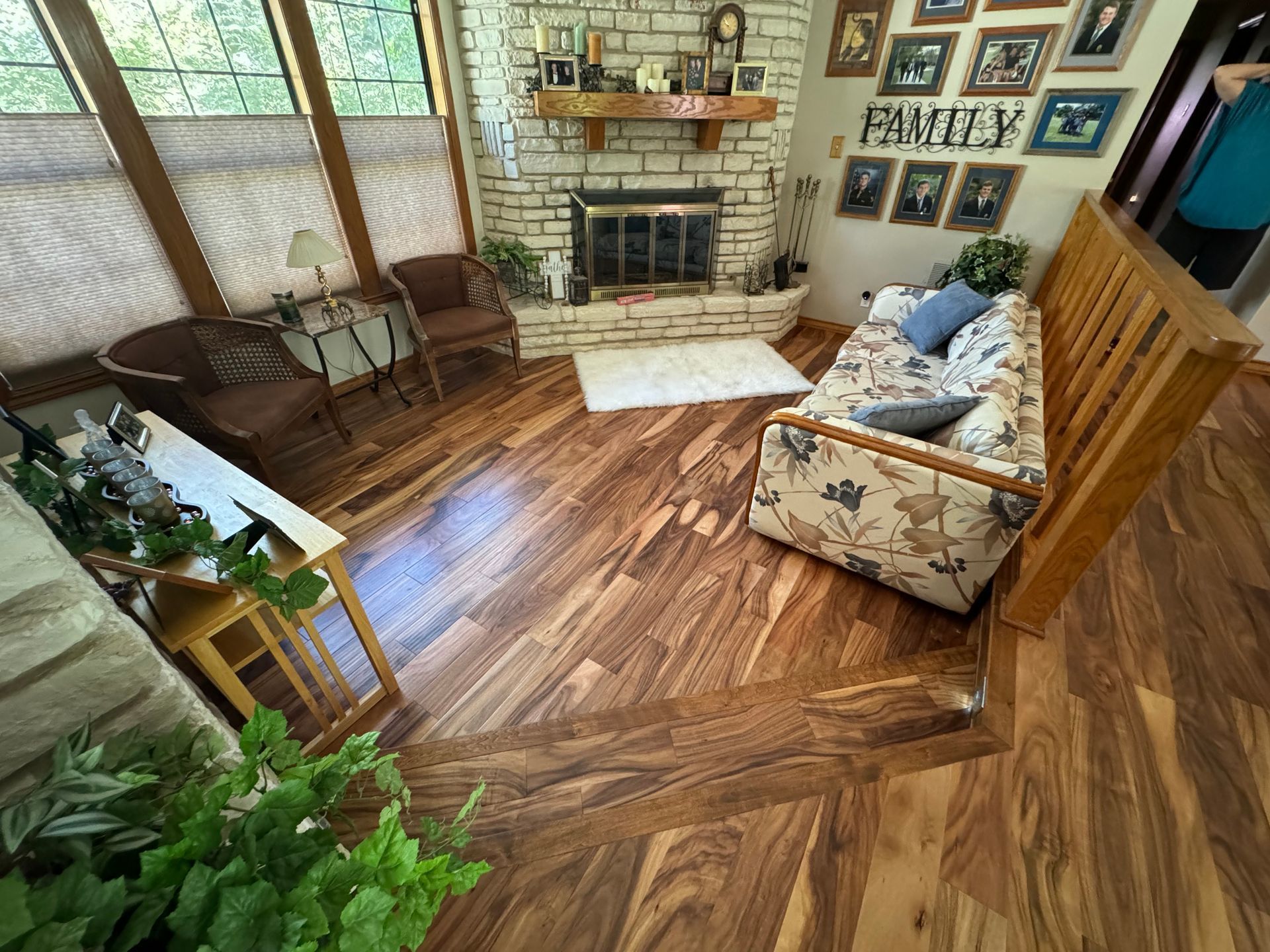 A living room with a wooden floor and a fireplace.