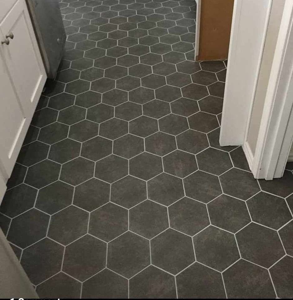 A kitchen with a hexagon tile floor and white cabinets