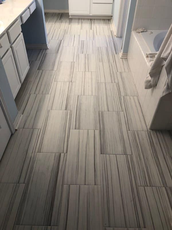 A bathroom with a tiled floor and a bathtub.
