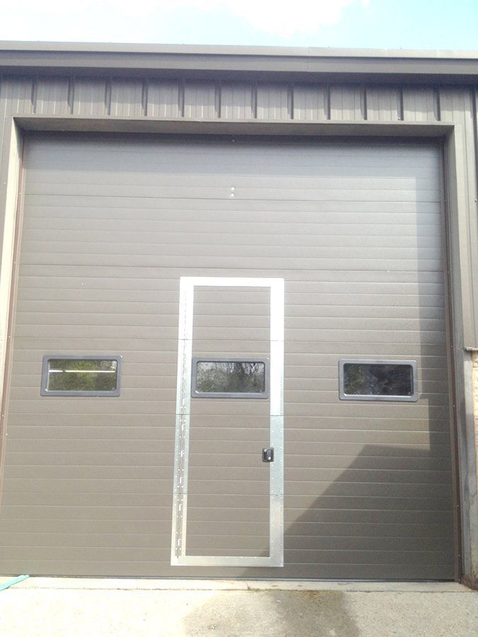 A garage door with a door and two windows on it
