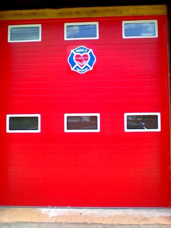 A red garage door with a heart and fire emblem on it