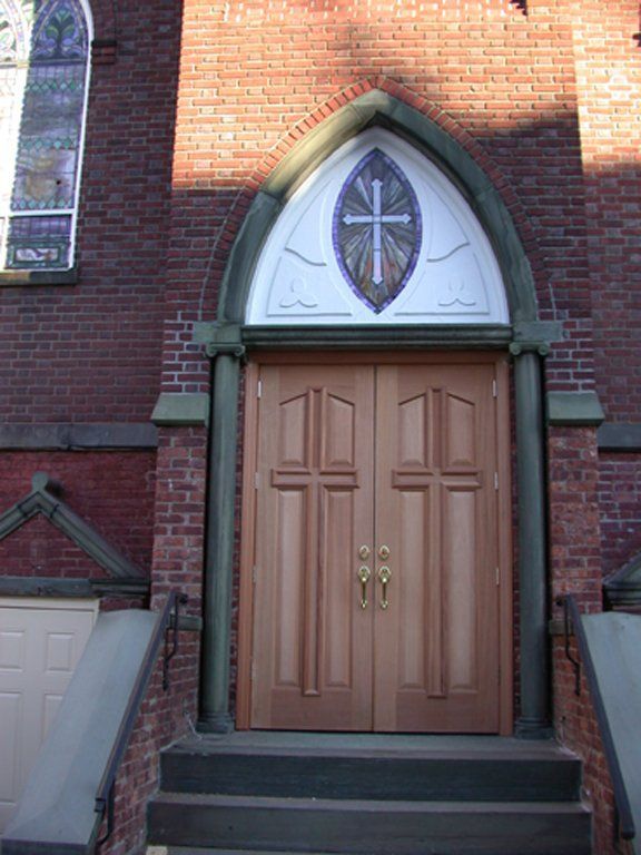 A wooden door with a cross on top of it