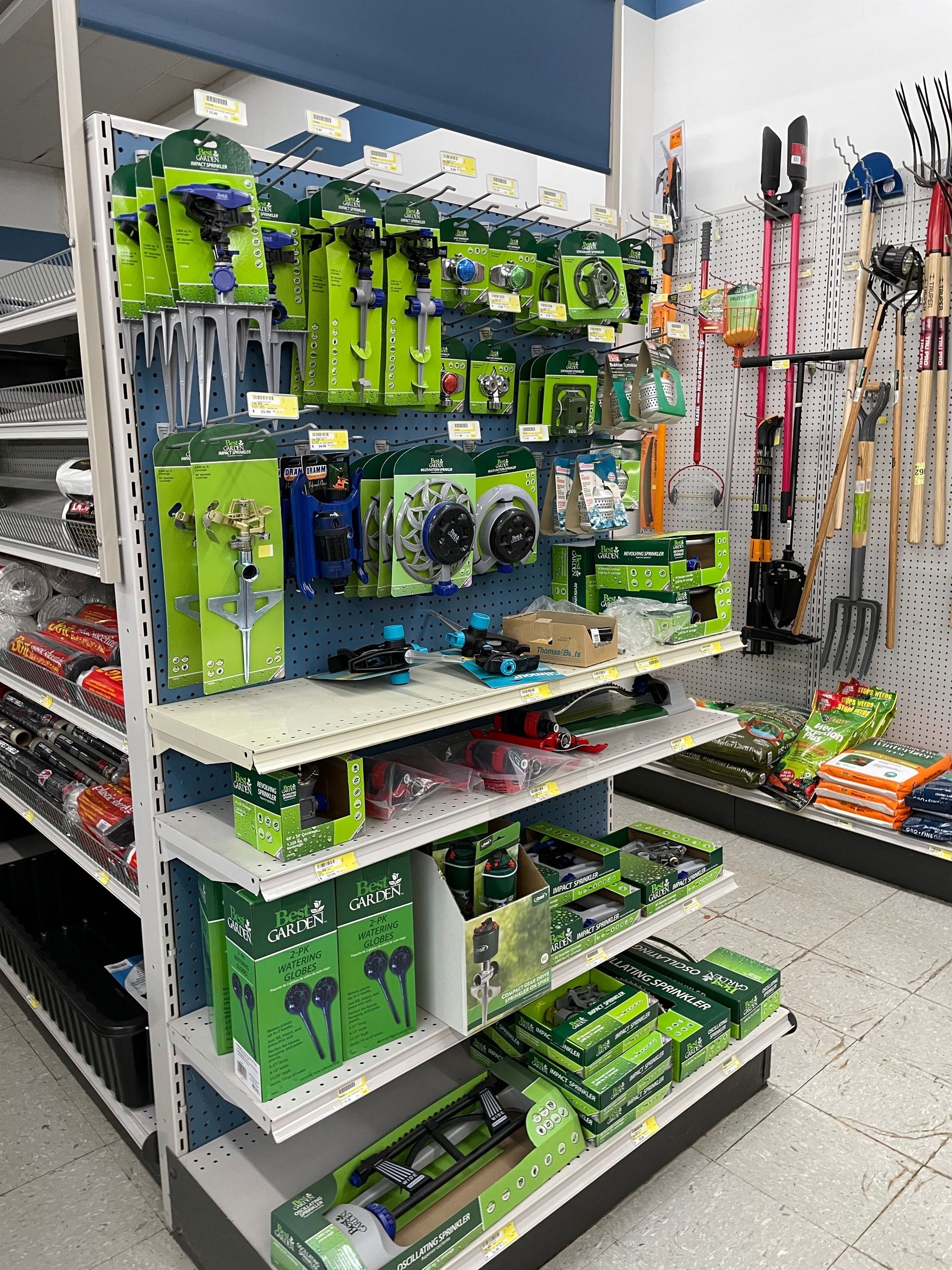 Shelves stocked with green and black hardware tools at a store.